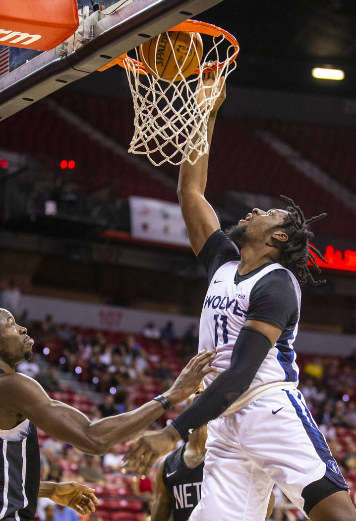 Minnesota Timberwolves center Naz Reid, right, dunks the ball over the Brooklyn Nets guard Jayl ...