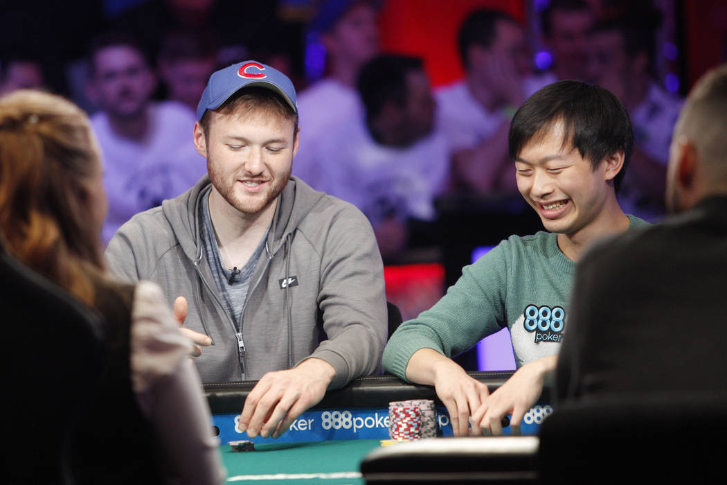 Kevin Maahs, left, talks with Timothy Su at the main event final table during the World Series ...