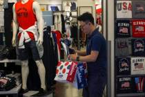 A man buys clothes from an American clothing store having a promotion sale at a shopping mall i ...