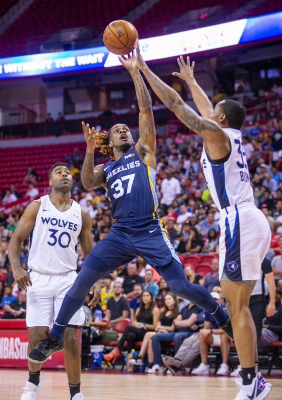 Memphis Grizzlies guard Paris Lee, left, gets off a shot over the Minnesota Timberwolves guard ...