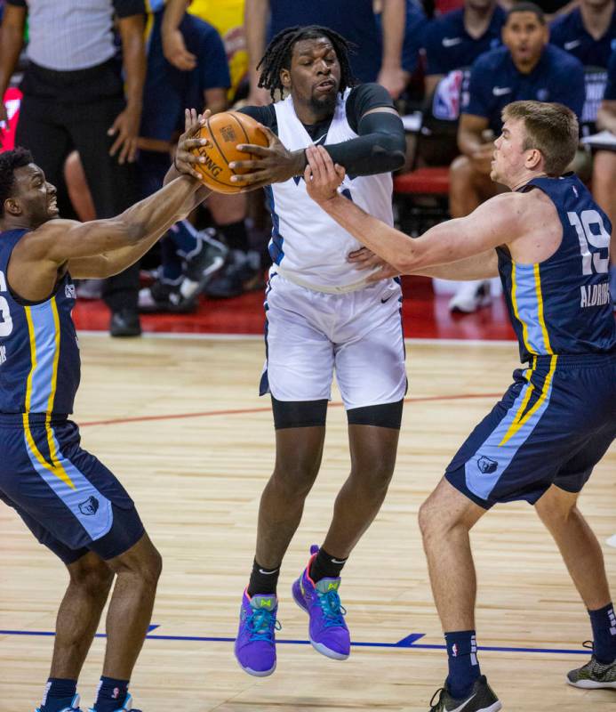 Minnesota Timberwolves center Naz Reid, center, fights for a rebound with Memphis Grizzlies gua ...