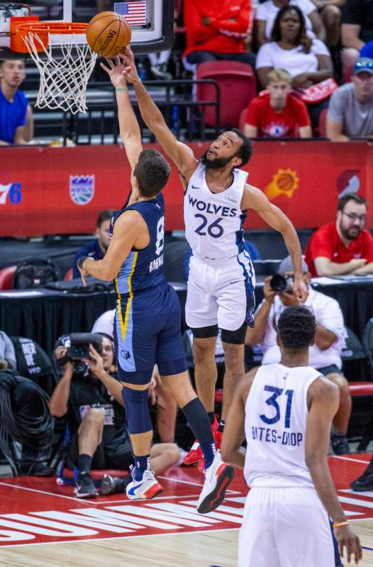 Memphis Grizzlies guard Dusty Hannahs, left, has a shot rejected by Minnesota Timberwolves guar ...