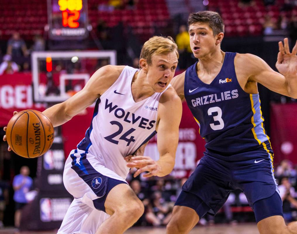 Minnesota Timberwolves guard Canyon Barry, left, drives the lane on Memphis Grizzlies guard Gra ...