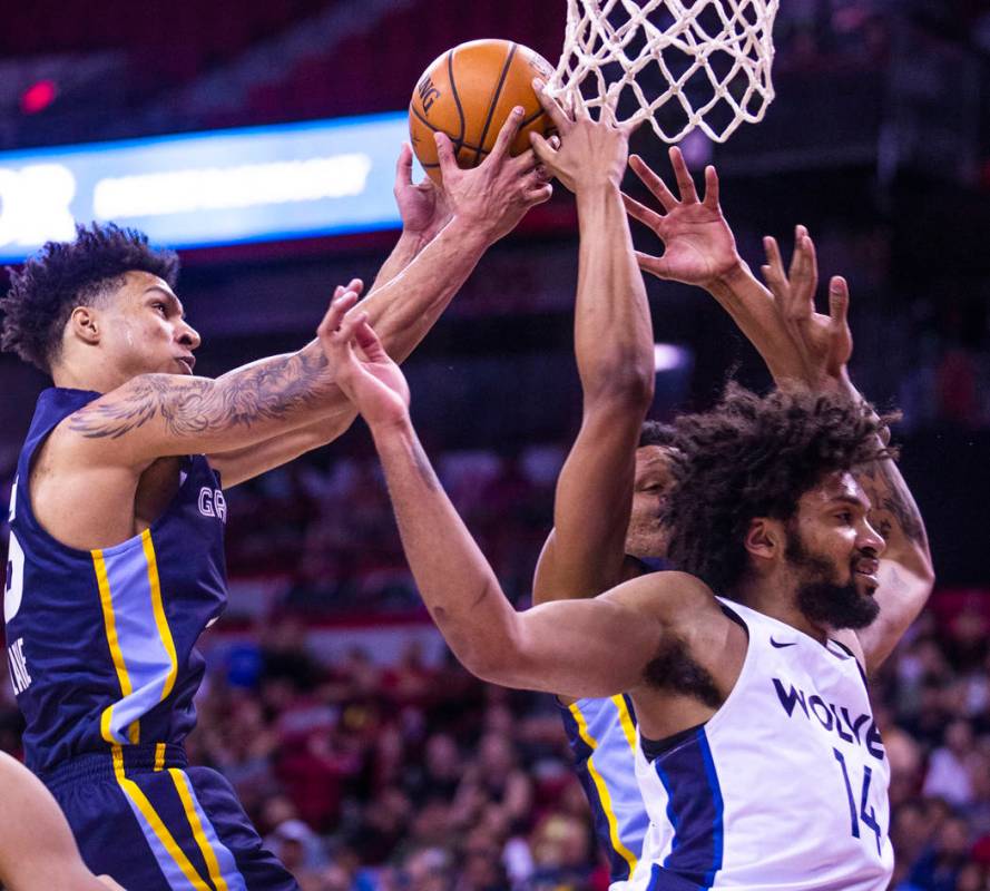 Memphis Grizzlies forward Brandon Clarke, left, pulls down a rebound over Minnesota Timberwolve ...
