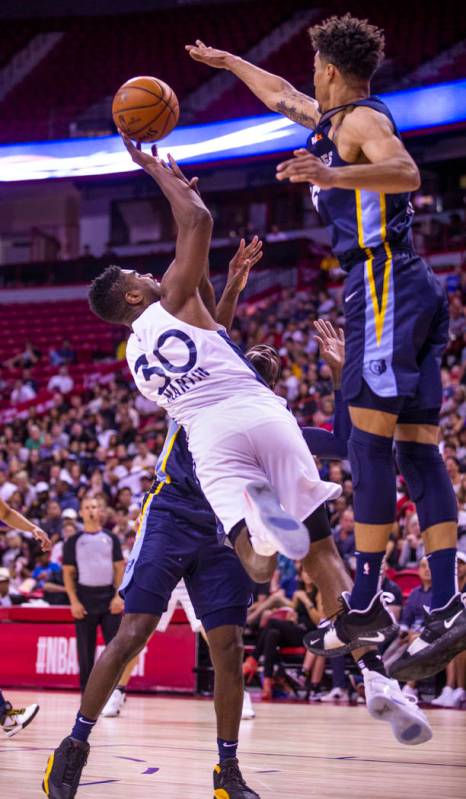 Minnesota Timberwolves forward Kelan Martin, left, releases a shot that will be blocked by Memp ...