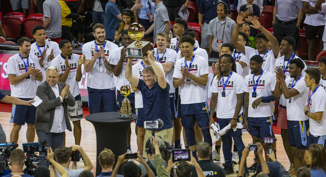 Memphis Grizzlies head coach Taylor Jenkins hoists the winning trophy after his team defeated t ...