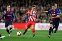 Atletico forward Antoine Griezmann, center, vies for the ball with Barcelona midfielder Arthur, ...