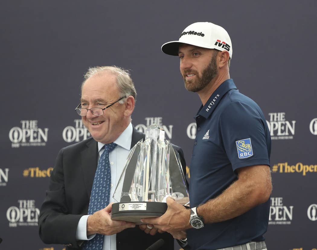 Dustin Johnson of the United States, right, receives The Mark H McCormack award for being the l ...