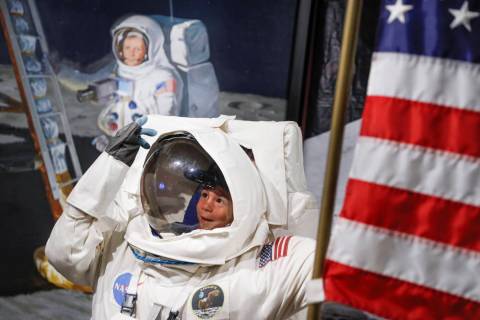 Visitors pose for photos beside a portrait of Neil Armstrong at the Armstrong Air and Space Mus ...