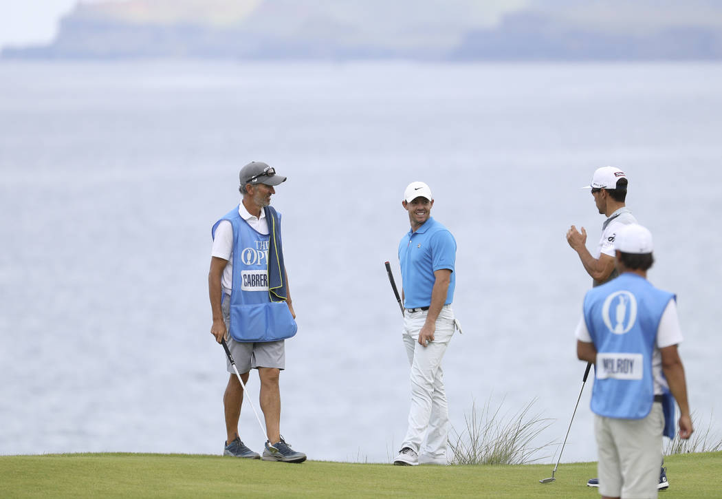 Northern Ireland's Rory McIlroy, centre talks to Spain's Rafa Cabrera Bello, right, on the 5th ...