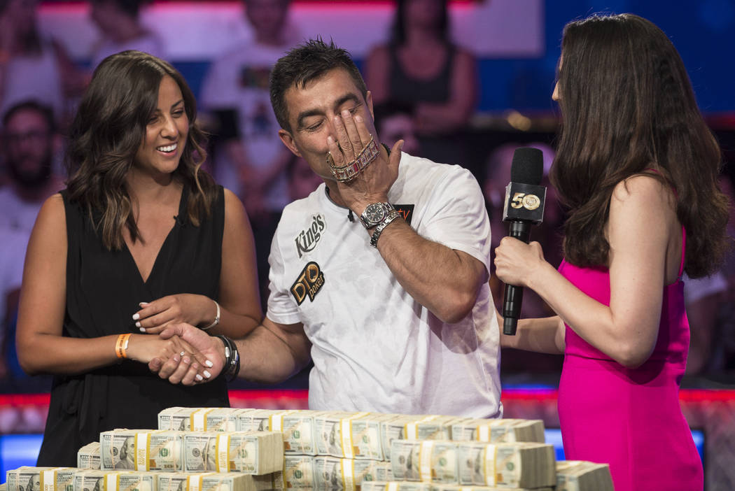 Hossein Ensan, middle, from Germany, kisses the championship bracelet after winning the World ...