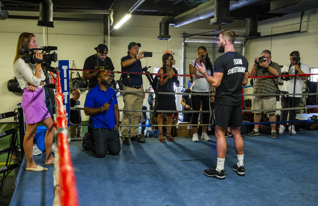 Boxer Caleb Plant, IBF super middleweight champion, center, gives an interview during a media d ...