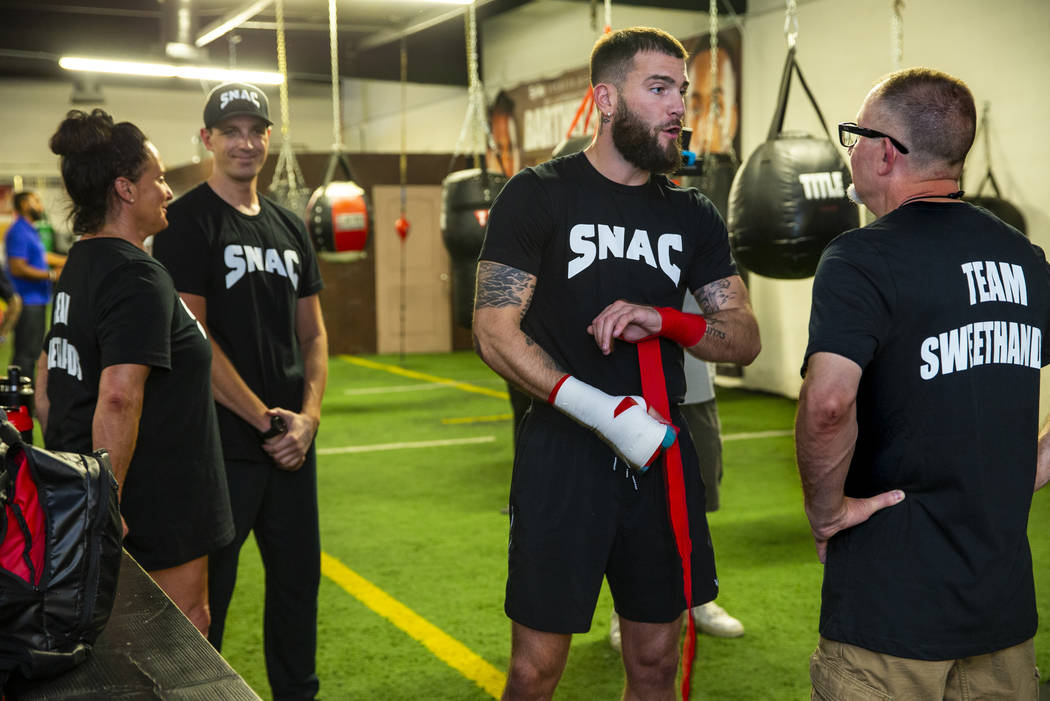 Boxer Caleb Plant, IBF super middleweight champion, center, confers with his father Richie Plan ...