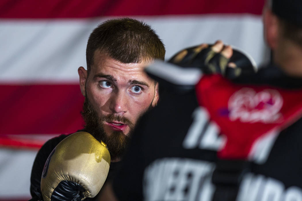 Boxer Caleb Plant, IBF super middleweight champion, punches a pad in the ring with trainer Just ...