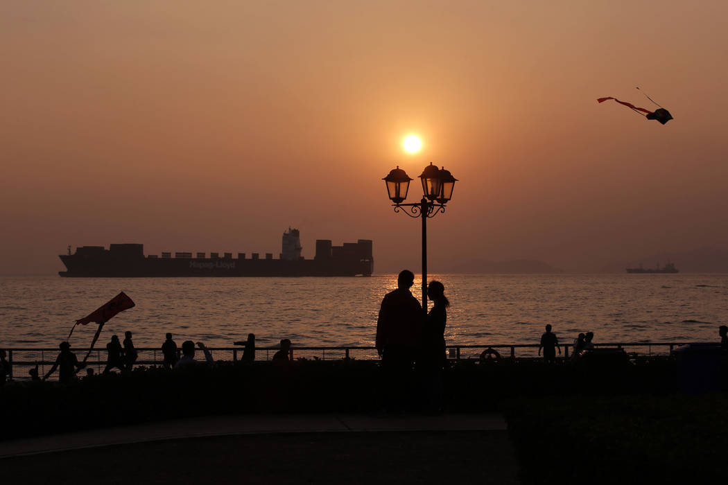 People enjoy their moment during the last sunset of year 2017 at a park in Hong Kong, Sunday, D ...