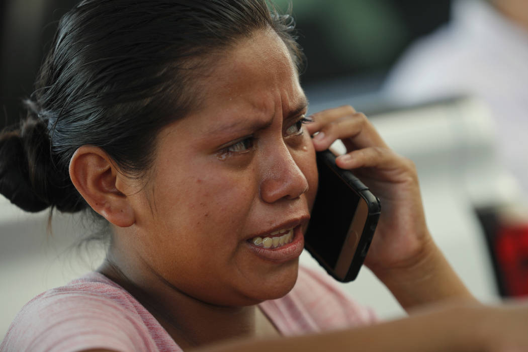 A migrant cries as she speaks on the phone, at an immigration center on the International Bridg ...