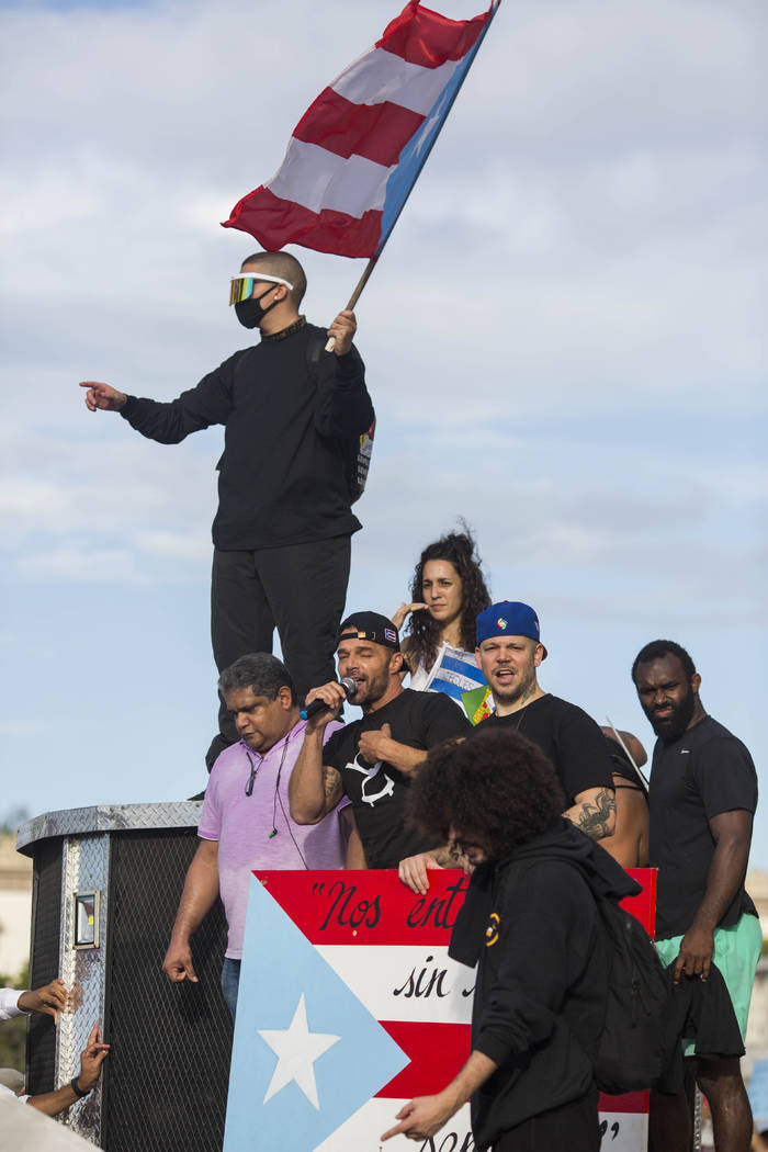 Singer Ricky Martin speaks to the crowd, accompanied by Puerto Rican rapper Rene Juan Perez kno ...