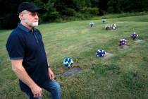 Eddie Davis stands beside the gravestone of his son Jeremy, furtherest left, who died from the ...