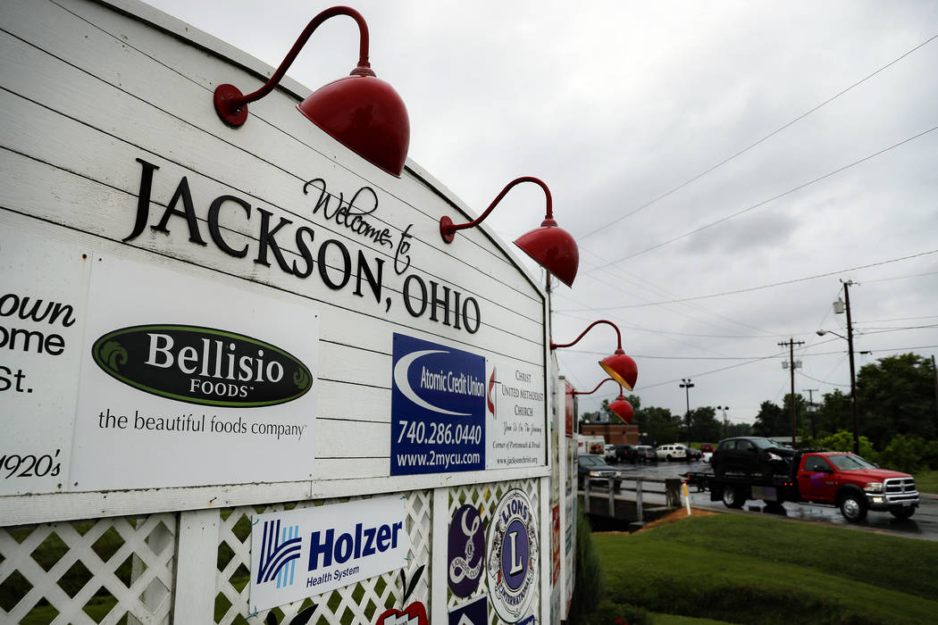 Traffic passes along a main thoroughfare as rain clouds gather overhead, Wednesday, July 17, 20 ...