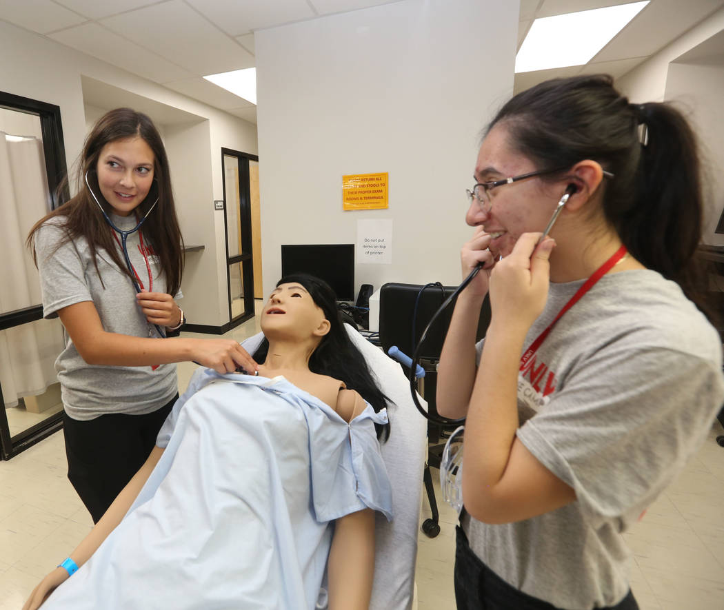 Students Vanessa Panfil, 17, left, and Dulce Hernandez, 18, right, practice breathing on a medi ...