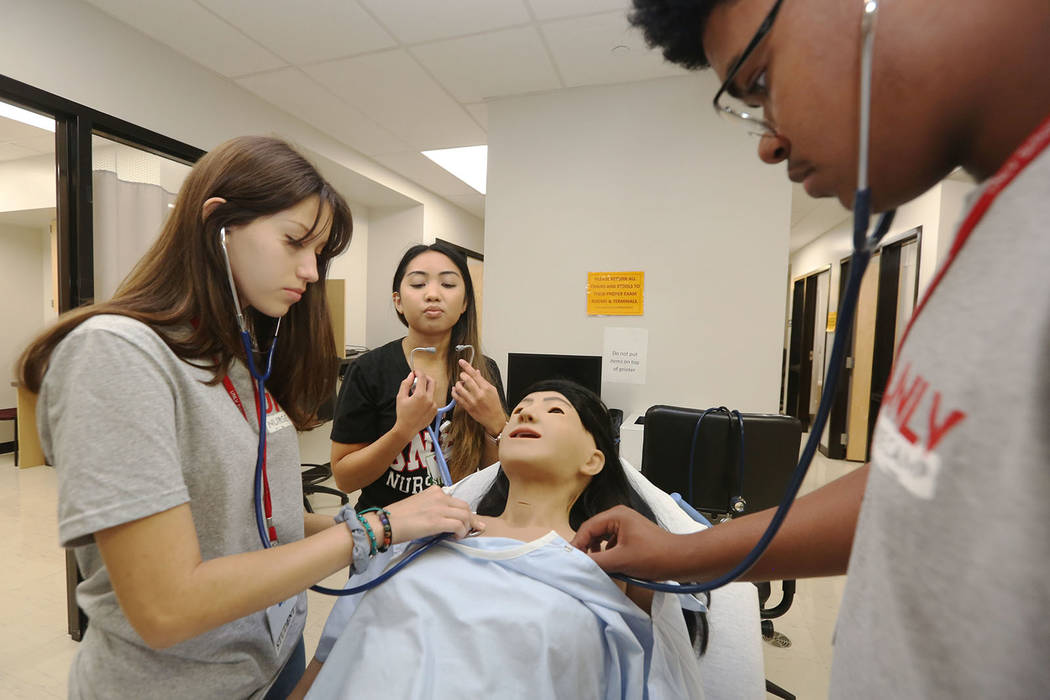 Mallory Gonzales, 17, left, and James Treadwell, 15, right, practice tube breathing on a medica ...
