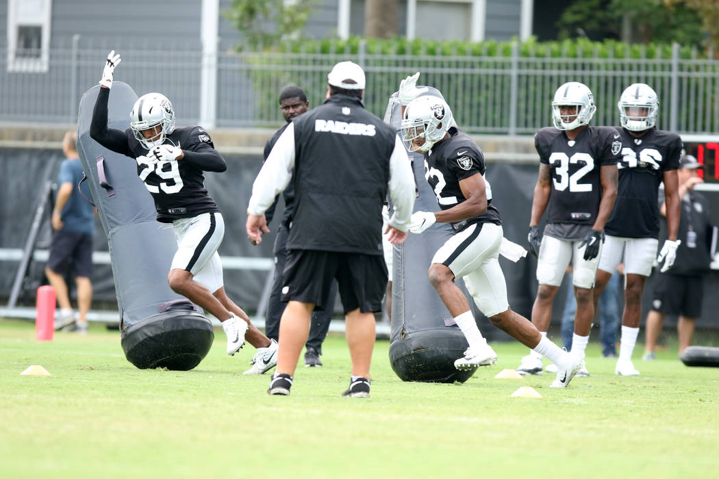 Oakland Raiders defensive backs Leon Hall (29) and Rashaan Melvin (22) brush by tackle posts as ...