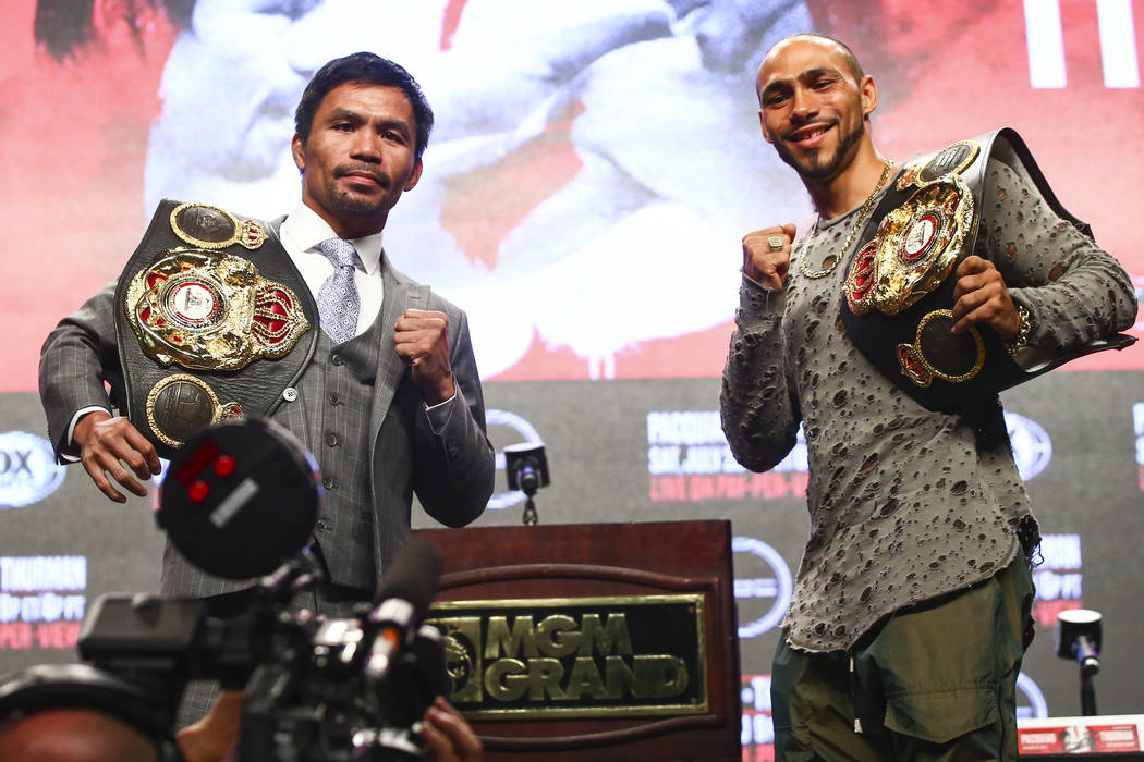 Manny Pacquiao, left, and Keith Thurman pose for pictures during a press conference ahead of th ...