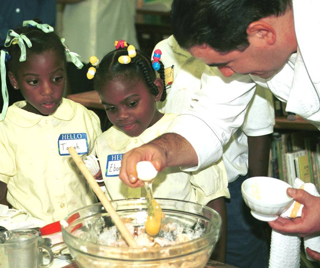 Tarah Mathews left, and Ebony Corner watch carefully as Chef Emeril Lagasse cracks the egg with ...