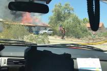 A Las Vegas Fire Department firefighter saves an American flag from a fire on July, 11, 2019. ( ...