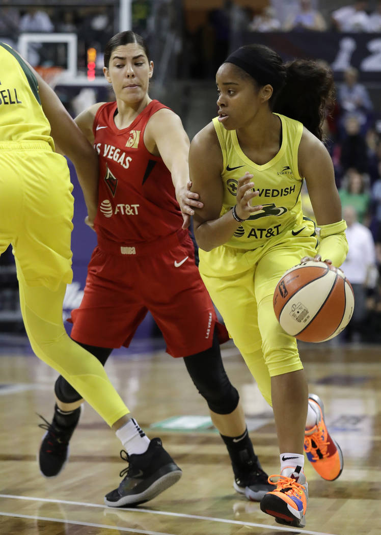 Seattle Storm's Jordin Canada, right, drives past Las Vegas Aces' Kelsey Plum during the first ...