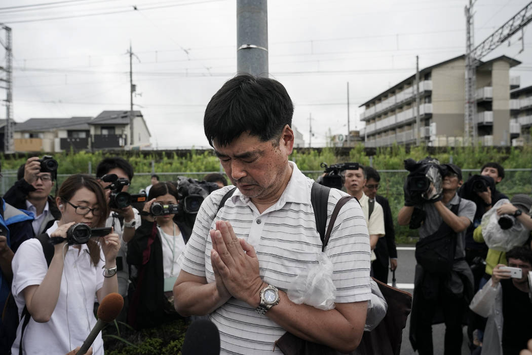 A man prays for the victims of Thursday's fire at the Kyoto Animation Studio building, Friday, ...