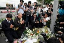 Japanese Diet member, Kenta Izumi, left, and Buddhist monk, Matsumoto Genkun, pay respects at a ...