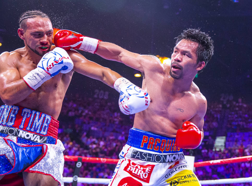 Keith Thurman is punches in the face by Manny Pacquiao during Round 5 of their WBA super welter ...