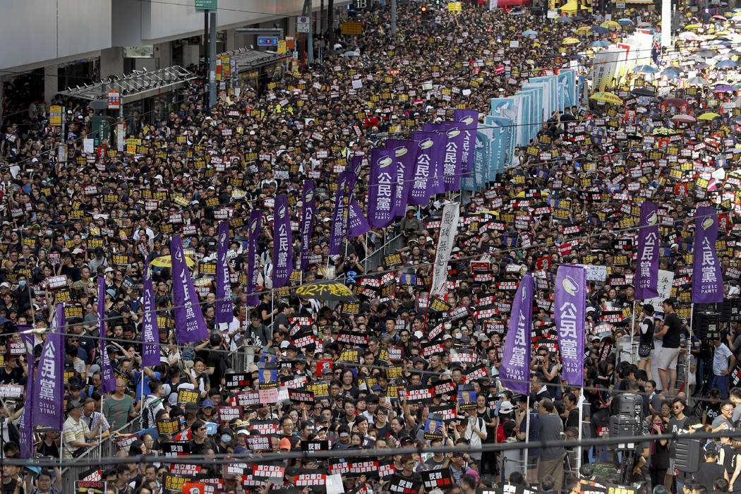 Protesters take part in a march on a street in Hong Kong, Sunday, July 21, 2019. Thousands of H ...
