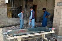 Hospital staff gather at the site of a bombing on an entrance of a hospital in Dera Ismail Khan ...