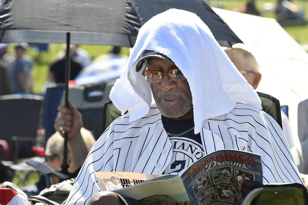 Mariano Rivera fan Eugenino Edwards, of New York uses a towel to keep cool before the National ...