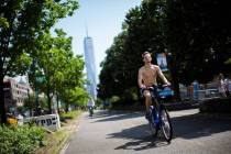 Cyclists ride down a path near the Hudson River during high temperatures on Saturday, July 20, ...