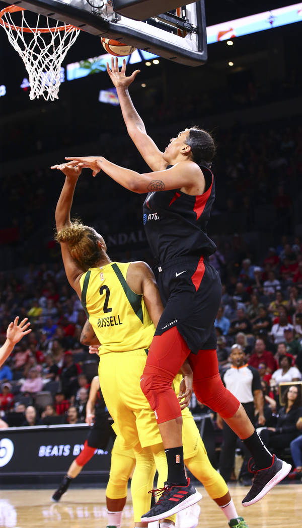Las Vegas Aces' Liz Cambage, right, lays the ball up past Seattle Storm's Mercedes Russell (2) ...