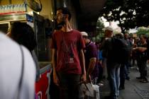 People walk in the streets of Caracas after a massive blackout left the city and other parts of ...