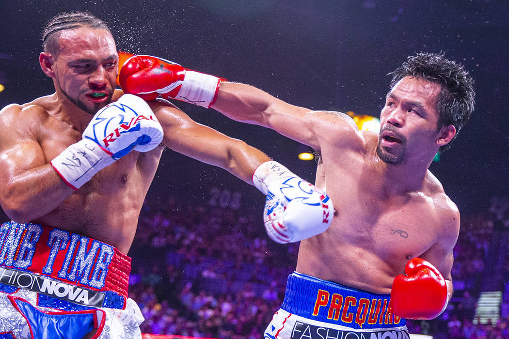 Keith Thurman is punches in the face by Manny Pacquiao during Round 5 of their WBA super welter ...