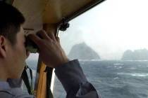 In this April 28, 2005, file photo, a South Korean coast guard looks at Dokdo islets, known as ...