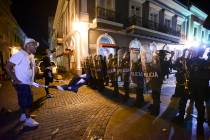 Demonstrators stand in front of riot control units during clashes in San Juan, Puerto Rico, Mon ...