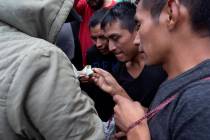 Guatemalan men who were deported from the United States, change money after arriving at the Air ...