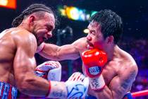 Keith Thurman, left, is punched in the face by Manny Pacquiao during Round 12 of their WBA supe ...