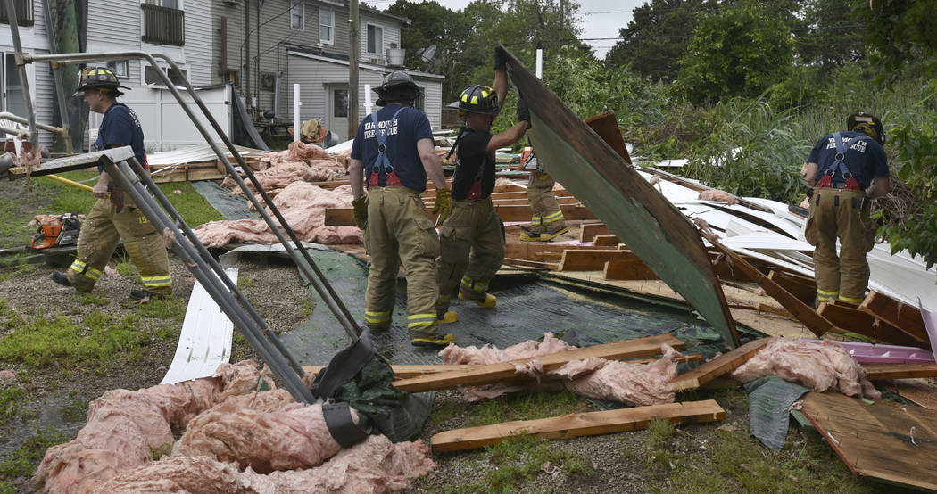 Yarmouth Fire crews look through the parts of the roof that blew off the Cape Sands Inn during ...