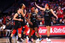 Las Vegas Aces players react during a break in the first half of a WNBA basketball game against ...