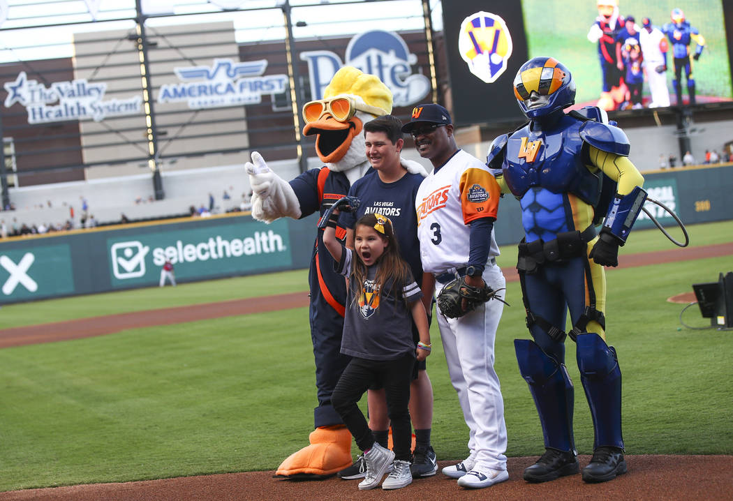 Nine-year-old Hailey Dawson, center, poses after throwing the first pitch with, from left, Spru ...