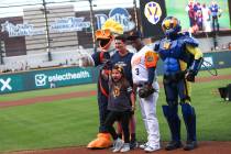 Nine-year-old Hailey Dawson, center, poses after throwing the first pitch with, from left, Spru ...