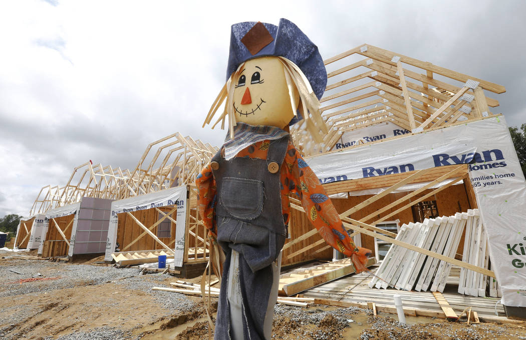 In this June 13, 2019, photo a scarecrow stands near a multi-family home construction site Mech ...