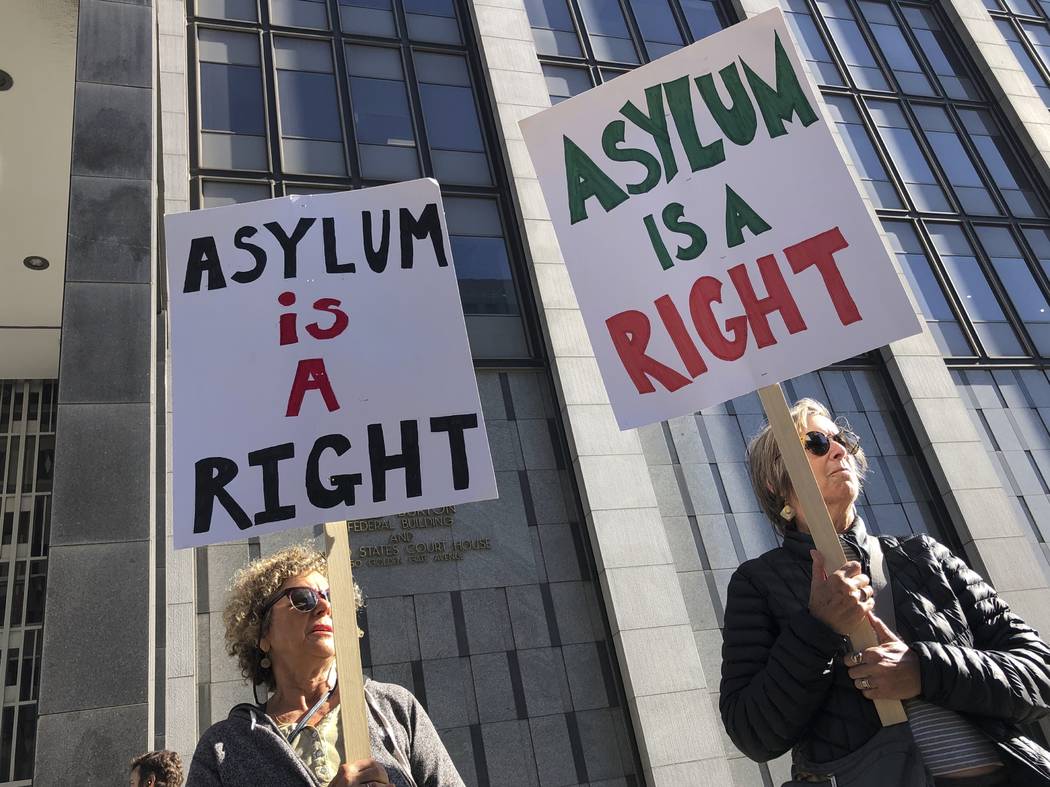 Protestors hold signs that read " Asylum is a Right" outside of the San Francisco Fed ...